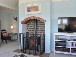 a living room with a fireplace and a tv at 1 Hamilton Terrace in Lamlash