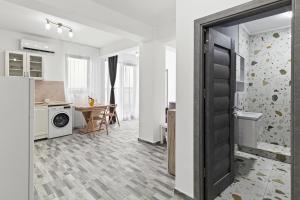 a kitchen with a door open to a living room at Azure Bliss Terrace Apartaments in Mamaia Nord
