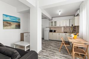 a kitchen and a living room with a table and chairs at Azure Bliss Terrace Apartaments in Mamaia Nord