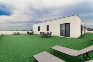 a white building with green grass on the roof at Azure Bliss Terrace Apartaments in Mamaia Nord