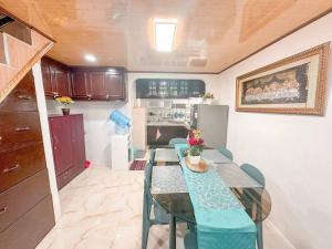 a dining room with a table and a kitchen at Maddox Homestay Fully airconditioned in Mandaue City