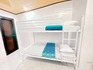 a white bunk room with white towels and a blue towel at Maddox Homestay Fully airconditioned in Mandaue City +28 photos