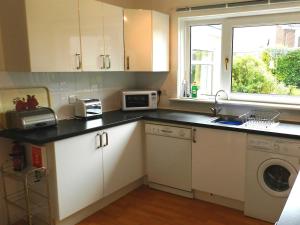a kitchen with a sink and a microwave at Hartholm in Brodick +5 photos