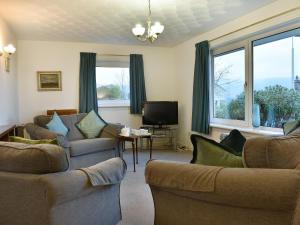 a living room with two couches and a tv at Hartholm in Brodick