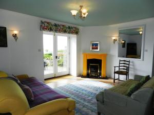 a living room with a couch and a fireplace at Castleside Croft in Kildonan