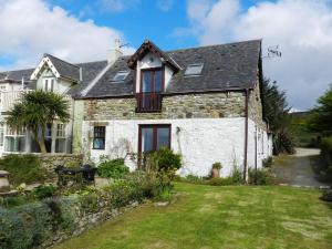 an old stone house with a yard at Castleside Croft in Kildonan