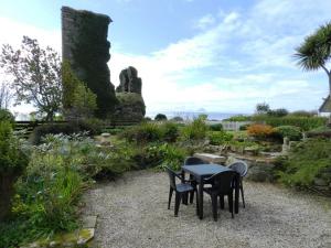 a table and chairs sitting in a garden at Castleside Croft in Kildonan +7 photos