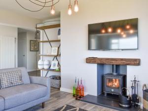 a living room with a fireplace and a couch at Kinneil Land in Lamlash