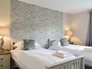 a bedroom with two beds and a wall with plates at Kinneil Land in Lamlash