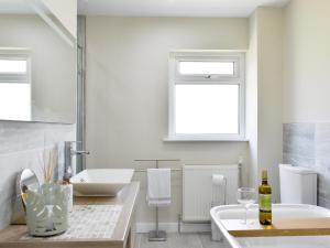 a bathroom with a tub and a sink and a bath tub at Kinneil Land in Lamlash +13 photos