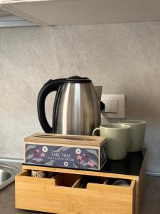 a coffee pot sitting on top of a wooden stand with cups at LA TORRE SARACENA - APARTMENTS with services & Free Parking in Palmi