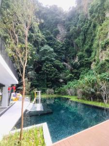 einen Pool vor einem Berg in der Unterkunft The Cove Hillside CosyStays in Ipoh