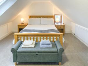 a bedroom with a bed and a couch with two towels at Woodlea Cottage 2 in Dippin