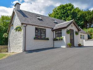 a white house with flower boxes on the windows at Woodlea Cottage 2 in Dippin