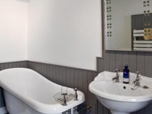 a bathroom with a bath tub and a sink at Woodlea Cottage 2 in Dippin +8 photos