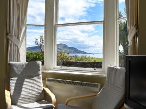 a room with two chairs and a large window at Hamilton Terrace in Lamlash