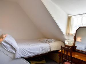a small bedroom with a bed and a mirror at Hamilton Terrace in Lamlash