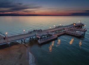 a pier on the water with people walking on it at Apartament Street Art ZASPA - wśród murali in Gdańsk