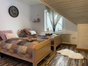 a bedroom with two beds and a clock on the wall at Casa del Sol in Reinsfeld