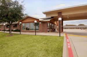 a building with a red curb in front of a building at Five Star Inn Burleson in Burleson