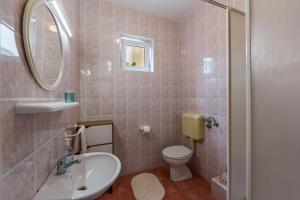 a bathroom with a sink and a toilet and a mirror at Apartments Claudia in Šmrika +42 photos
