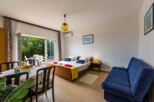 a living room with a bed and a dining room at Apartments Claudia in Šmrika