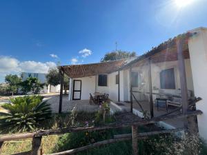 una casa blanca con una cerca al lado en La Casa del Carrubo con Piscina condivisa in campagna vicino al mare - Canestanco 18, en Santa Croce Camerina