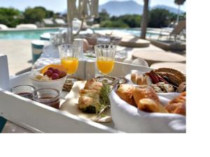 a table with a tray of food and glasses of orange juice at Portes Houses in Koufonisia