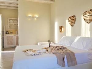 a white bed with a pile of towels on it at Portes Houses in Koufonisia