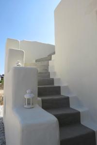 a stairway with a small bell on a table at Portes Houses in Koufonisia