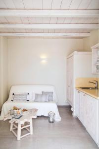 a white bedroom with a bed and a table at Portes Houses in Koufonisia