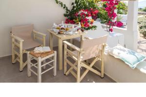 a table and two chairs and a table with flowers at Portes Houses in Koufonisia