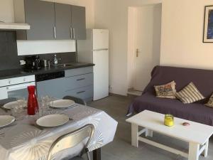 皮耶特罗塞拉Corsicadream cupabia, appartement dans villa proche Porticcio, vue mer, piscine的一间厨房和一间带桌子和沙发的客厅