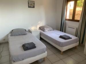 皮耶特罗塞拉Corsicadream cupabia, appartement dans villa proche Porticcio, vue mer, piscine的两张床位于一个有窗户的房间里