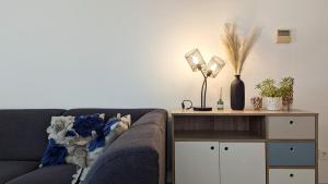 カーラ・デ・フィネストラットにあるVILA PARK Rooftop Apartmentのソファとランプ付きのテーブルがあるリビングルーム