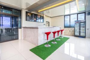 a bar with four red stools in a restaurant at Grand Valonia Hotel Cafe & Park Jember in Jember