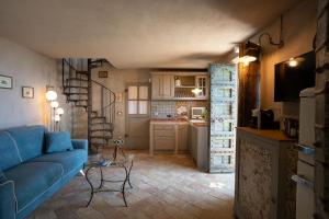 a living room with a blue couch and a kitchen at La Casa sul Forte in Seravezza