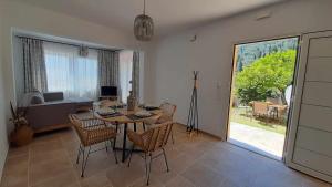 a dining room with a table and chairs and a couch at Rozas house in Benitses