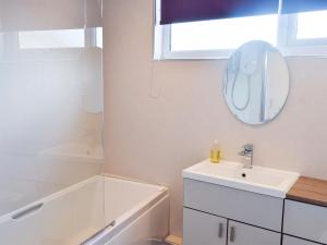 a bathroom with a sink and a tub and a mirror at The Old Reading Room in Bamburgh +8 photos