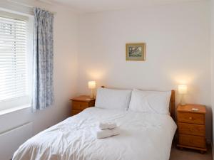 a bedroom with a white bed with two night stands at The Old Reading Room in Bamburgh