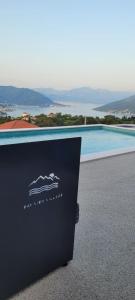 a sign sitting in front of a swimming pool at Bay View Village -Villa Eléanora 4 in Herceg-Novi