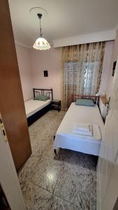 a bedroom with two beds and a chandelier at LY apartment in Kallithea Halkidikis