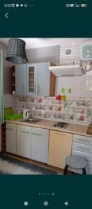 a kitchen with white cabinets and a counter top at Kawalerka pod jabłonią in Wielki Kack