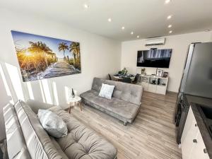 a living room with a couch and a flat screen tv at Palace City Apartman,T13, AC, Klima in Székesfehérvár