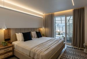 斯基亚索斯镇Serenity Suites, Premium Key Collection的一间带大床的卧室和一个阳台 更多35张照片