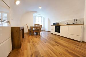 Una cocina y un comedor con mesa y sillas. en Apartments Metro 7, en Liubliana