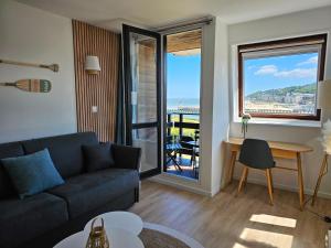 a living room with a couch and a view of the ocean at Ocea Marina appartement vue mer refait à neuf avec parking privatif in Deauville