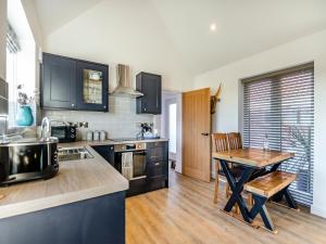 a kitchen with a wooden table and a wooden floor at The Cowshed - Uk37349 in Hockerton