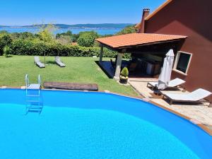 a large blue swimming pool next to a house at Chalet Rural Toñita 400 m playa piscina barbacoa chimenea in Bueu