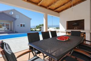 a dining room with a black table and chairs at Holiday home Fjaka with swimming pool in Pridraga